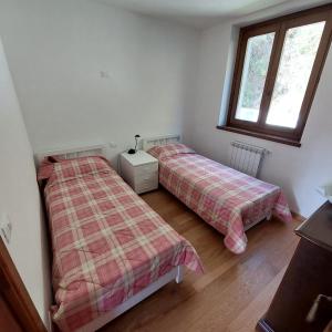 フィウマルボにあるCasa vacanza Doganaの窓が2つある部屋にベッドが2つある +5枚の写真