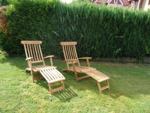 two wooden chairs sitting on the grass in a yard at Ferienwohnung Lautenbach in Bad Sachsa