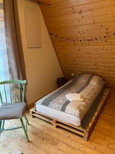 Bett in einem Zimmer neben einem Stuhl in der Unterkunft Halo domek in Szczyrk
