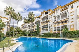 a swimming pool in front of some buildings at Apartamento Costa Nagüeles 2hab. in Marbella