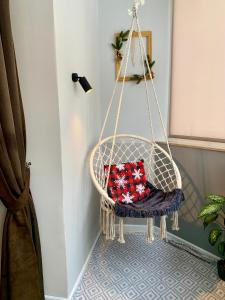 a hanging chair with a red pillow in a room at Comfort Home Soborna 283 in Rivne