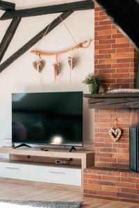a living room with a television and a brick fireplace at Auszeit im Rheingau in Eltville