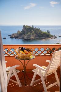 a bowl of food sitting on a table with two chairs at Mendolia Beach Hotel in Taormina