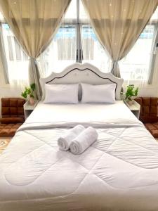 1 dormitorio con 1 cama blanca y 2 toallas en Guesthouse Station, en Bangkok