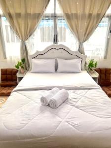 Un dormitorio con una cama blanca con dos toallas encima. en Guesthouse Station, en Bangkok