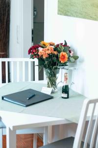 a table with a vase of flowers and a bottle of wine at Auszeit im Rheingau in Eltville