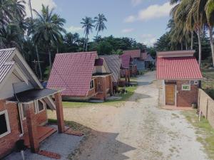Une rangée de maisons sur un chemin de terre dans l'établissement Zainab Cottage, à Pasir Puteh