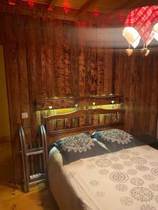 ein Schlafzimmer mit einem Bett mit einer Holzwand in der Unterkunft Appartement chaleureux (chalets) in Rencurel