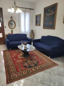 un soggiorno con 2 divani blu e un tavolo di Casa Argia a Padova