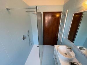 biała łazienka z umywalką i prysznicem w obiekcie Casa Argia w Padwie