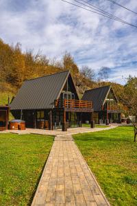 a large building with a black roof in a park at Valea Mosului - Cozy A Frame in Petroşani