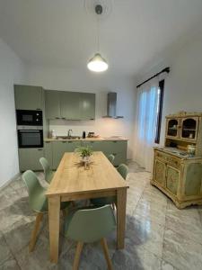 a kitchen with a wooden table and green chairs at Casa Argia in Padova