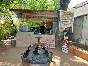 a man standing at a counter in a food stand at Victoria Falls Backpackers Lodge in Victoria Falls