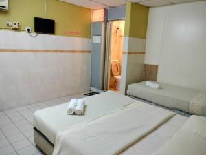 a hotel room with two beds and a bathroom at Grand Heritage Hotel in Melaka