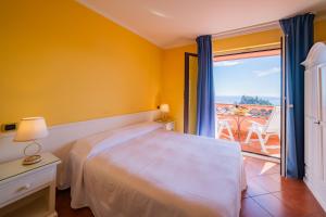 a bedroom with a bed and a view of the ocean at Mendolia Beach Hotel in Taormina