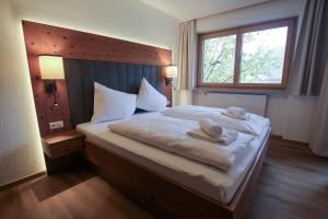 a bedroom with a large bed with towels on it at Hochtenn Lodge in Zell am See - Steinbock Lodges in Zell am See