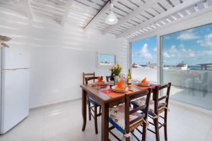 una sala da pranzo con tavolo e sedie e una grande finestra di I Tre Golfi - Appartamenti con Terrazzo fino a 800 mt dal mare a San Vito lo Capo