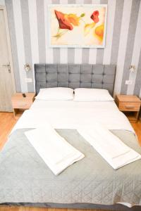 een slaapkamer met een bed met witte lakens bij Casa Millelune in Focşani