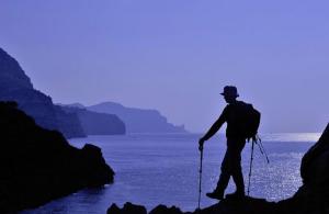 a man is standing on a rock by the water at La Petite Calanque in Marseille