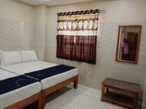 a bedroom with a bed and a mirror and a window at Vishnu Bhavan in Tirupati