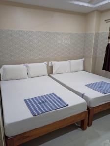 two beds sitting next to each other in a room at Vishnu Bhavan in Tirupati