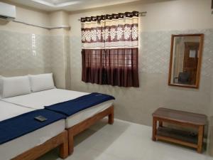 a small bedroom with a bed and a window at Vishnu Bhavan in Tirupati