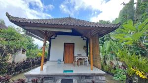 a small house with a wooden door and a table at The Bukit Artha in Sidemen +18 photos
