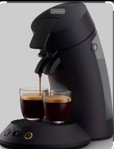eine schwarze Kaffeemaschine mit zwei Tassen Kaffee in der Unterkunft s`Haus am Inn in Pfunds