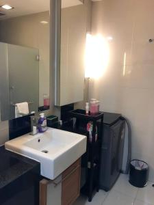uma casa de banho com um lavatório branco e um espelho. em Backpackers Cozy Apartment KL Sentral em Kuala Lumpur