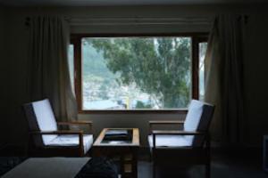 Zimmer mit 2 Stühlen, einem Tisch und einem Fenster in der Unterkunft The Mandala Hotel Dirang in Dirang Dzong