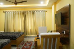 a hotel room with a bed and a tv and a room at The Mandala Hotel Dirang in Dirang Dzong