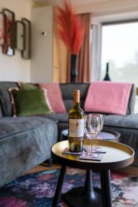 een fles wijn op een tafel met twee glazen bij Davis residence in Voorthuizen