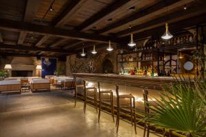 un restaurante con un bar con mesas y sillas en Hotel Le Dune Piscinas, en Ingurtosu
