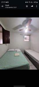 a bedroom with a bed and a ceiling fan at Pousadinha- Melhor Localização in Porto Seguro