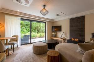 a living room with a couch and a fireplace at Storrs Hall Hotel on the shore of Lake Windermere in Bowness-on-Windermere