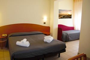 チェゼナーティコにあるHOTEL VILLA MARIAのベッドルーム1室(ベッド1台、タオル2枚付)