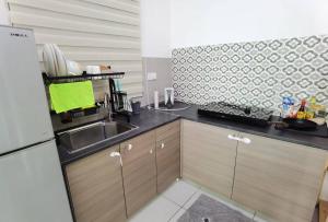 een keuken met een wastafel en een aanrecht bij Cozy&Comfort Suite Perai in Jalan Baharu