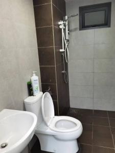 a bathroom with a white toilet and a sink at Cozy&Comfort Suite Perai in Jalan Baharu