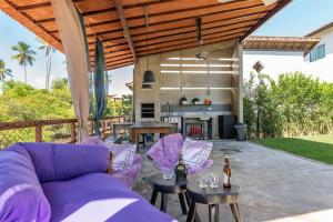 eine Außenterrasse mit einem lila Sofa und Stühlen in der Unterkunft Casa em Toquinho/Porto de galinhas in Porto De Galinhas