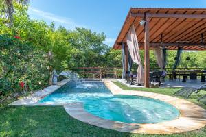 einen Pool im Garten mit einem Tisch in der Unterkunft Casa em Toquinho/Porto de galinhas in Porto De Galinhas
