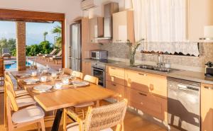 een keuken met een houten tafel en een eetkamer bij Iris Villas Lefkada - Karavi Villa in Évyiros