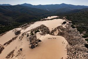 una vista aérea de un desierto con montañas en el fondo en Hotel Le Dune Piscinas, en Ingurtosu