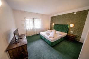 a bedroom with a green bed and a desk at Popas Turistic Transfagarasan in Cîrţişoara +56 photos