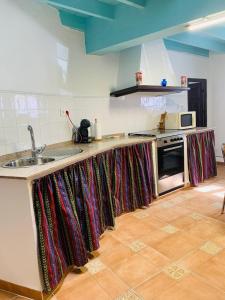 una cocina con una encimera con cortinas coloridas. en Casa Boneta Alpujarra Almeria-Alboloduy, en Almería