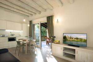 een keuken en een woonkamer met een tv aan de muur bij Al segnavento Tramontana in Toscolano Maderno