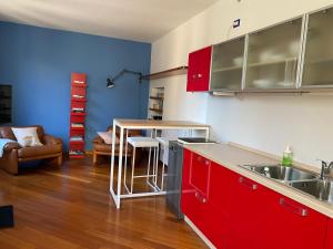a kitchen with red cabinets and a living room at La Porta Azzurra - Casa Vacanze in Como