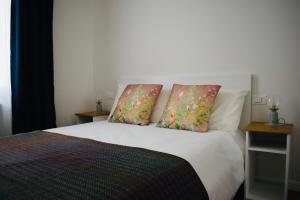 a bedroom with a white bed with two pillows at Nuovissimo trilocale in centro : Ca’ Del Mar in Sanremo