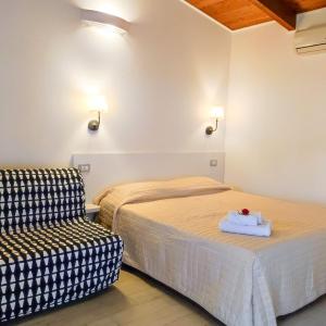 una camera d'albergo con due letti e una sedia di Arco delle Rose Rooms ad Agropoli
