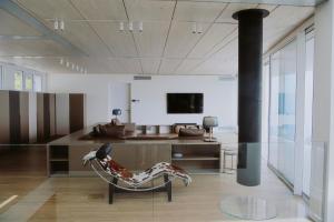 a living room with a chair and a television at Infinity Villa Salò in Salò