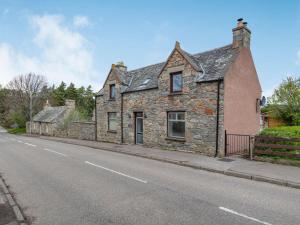 an old stone house on the side of a street at 4 Bed in The Cairngorms 46162 in Tomintoul